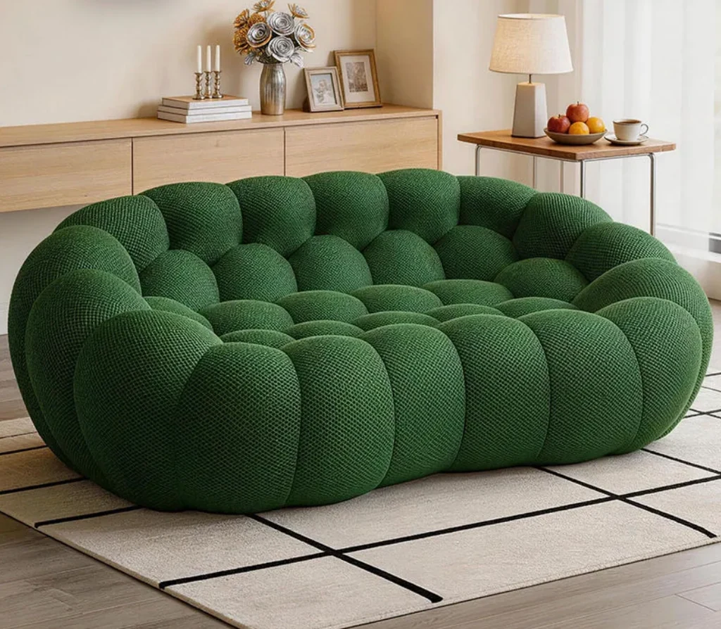 Rounded emerald green tufted sofa in a bright living room